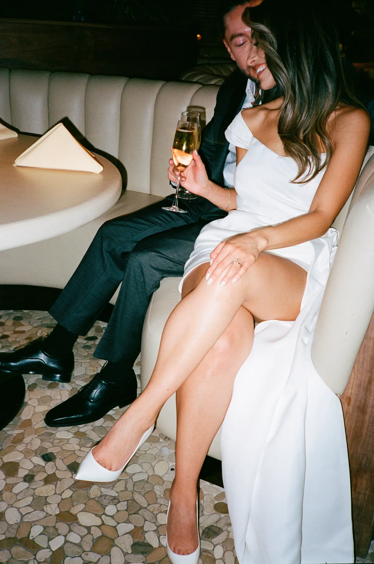 Couple sharing champagne in a low-lit bar