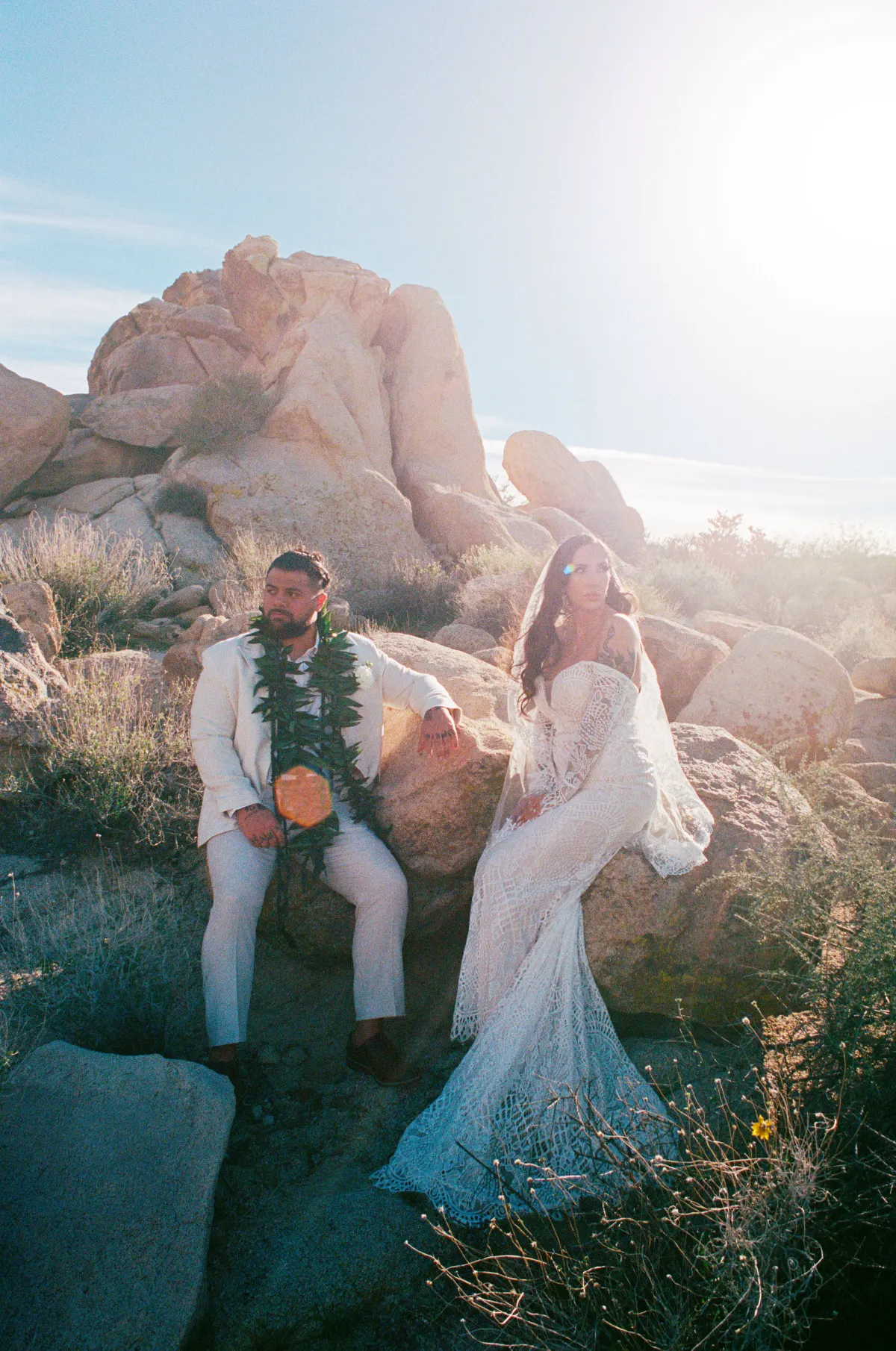 Couple sitting among desert rocks, soft editorial light
