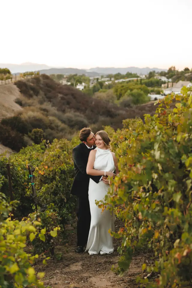 Newlyweds embracing among the Temecula vineyards at Villa de Amore