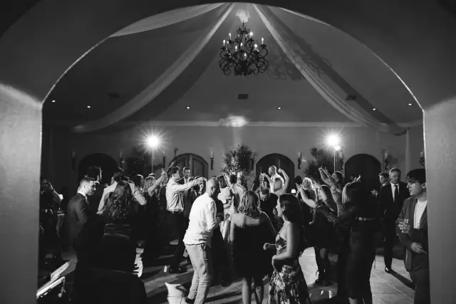Wedding guests dancing beneath the chandeliers at Villa de Amore