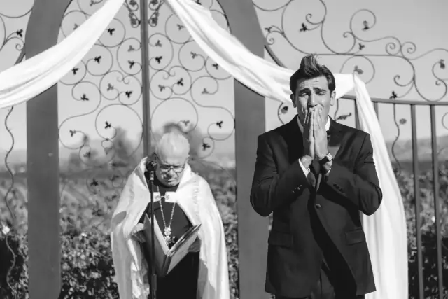 Emotional groom standing beneath the ceremony arch at Villa de Amore