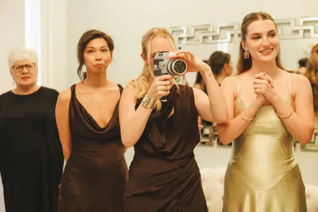 Bride and bridesmaids taking a mirror photo while getting ready