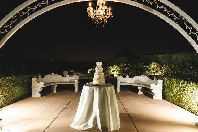 Wedding cake illuminated beneath the courtyard arch at Villa de Amore