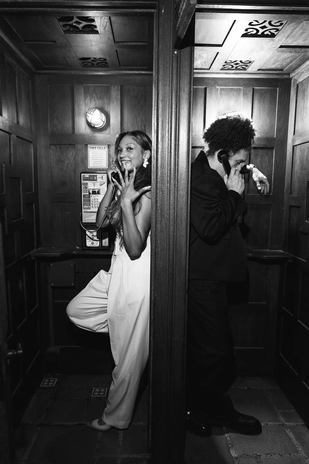 Black-and-white portrait of newlyweds sharing a quiet moment in a wood-paneled room